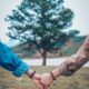 two persons holding hands