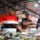 Vibrant street vendors in Jakarta preparing traditional snacks at a busy market.