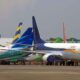 Multiple commercial airplanes parked on an airport runway.