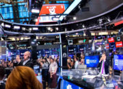 Tampilan layar perdagangan saham di Wall Street dengan grafik indeks yang fluktuatif