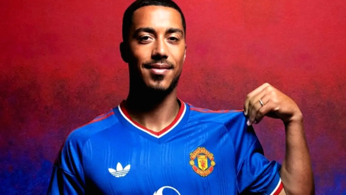 Rapper Stormzy mengenakan jersey tandang Manchester United musim 2026/2027 berwarna biru dengan gaya retro.