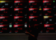 Papan layar elektronik yang menampilkan grafik penurunan Indeks Harga Saham Gabungan di bursa efek