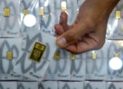 Kepingan emas batangan Antam dengan latar belakang putih