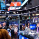 Papan layar elektronik yang menampilkan grafik kenaikan indeks saham di Wall Street, New York.