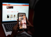 Ilustrasi transaksi belanja online di layar ponsel pintar dengan latar belakang perkantoran Jakarta
