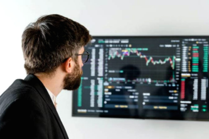 Layar monitor menampilkan grafik pergerakan saham dan data transaksi di Bursa Efek Indonesia