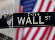Papan layar elektronik yang menampilkan pergerakan indeks saham Wall Street di New York