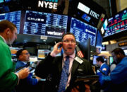 Papan layar elektronik yang menampilkan pergerakan indeks saham Wall Street di New York